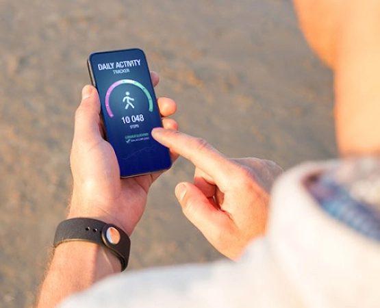 Man using a daily activity tracking app on a mobile phone showing 10,000 steps daily goal achievemen