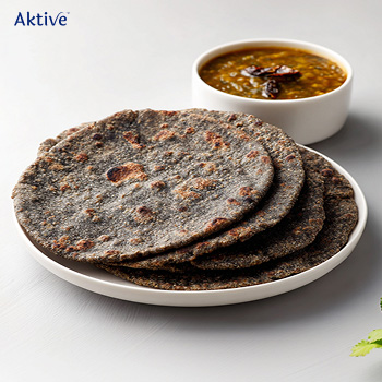 Bajra roti with lentil soup on a white plate