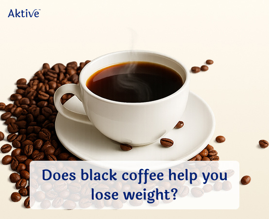 A cup of black coffee with coffee beans surrounding it