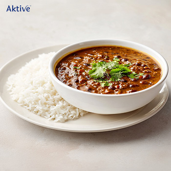 Dal makhani and vegetable rice in a bowl on a table