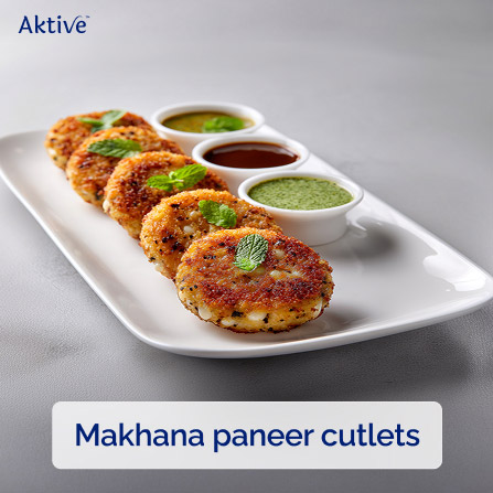 Makhana paneer cutlets arranged in a row on a white dish with 3 small bowls of chutney.