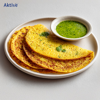 Moong dal chillas served on a plate with green chutney