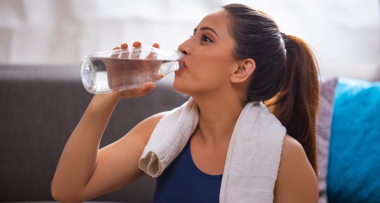 Indian woman drinking from a bottle of water