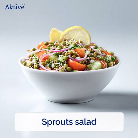 Sprouts with freshly cut vegetables and lemon slices in a bowl.